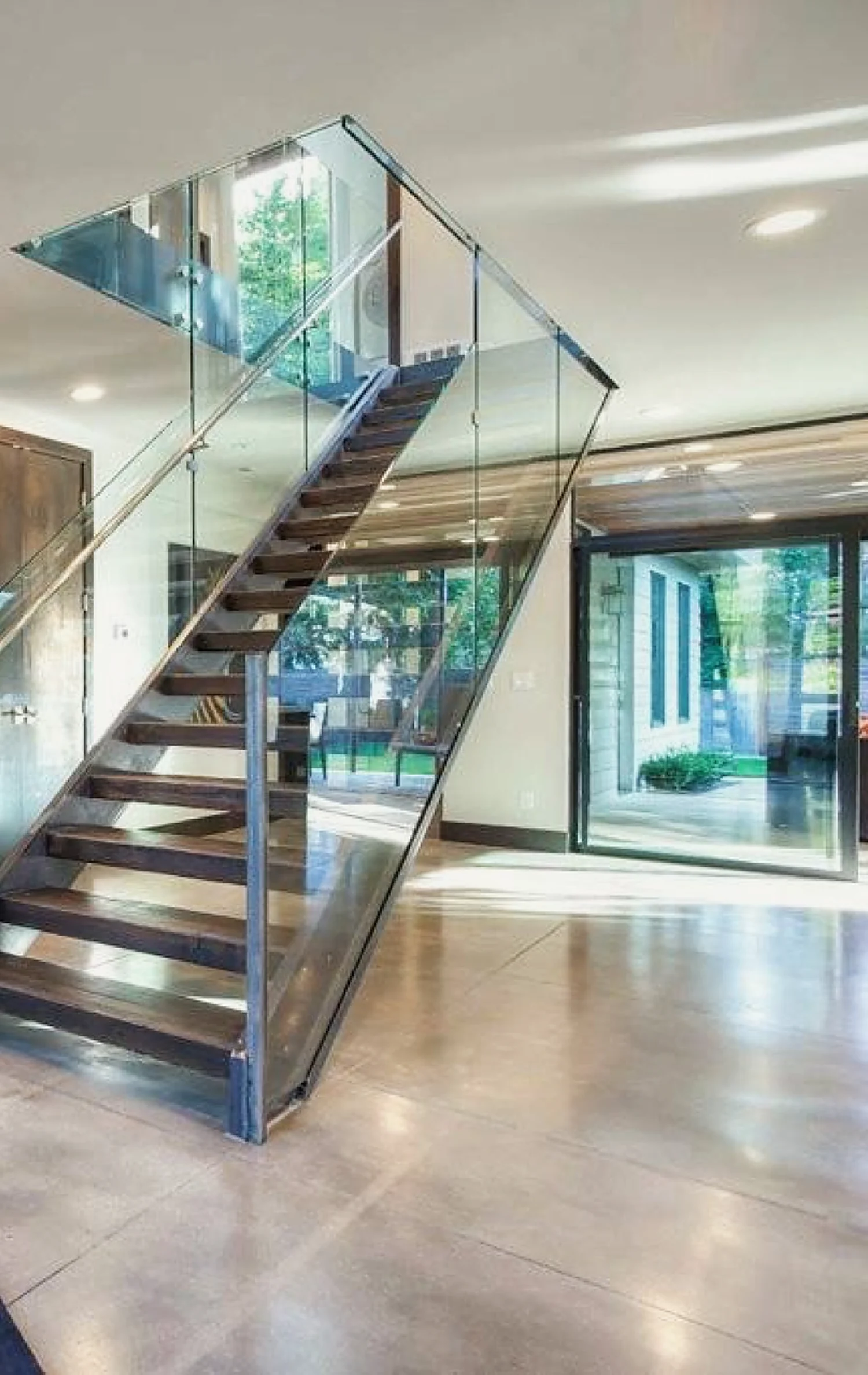 Floating-tread staircase with a glass balustrade, built by RM Construction & Design.
